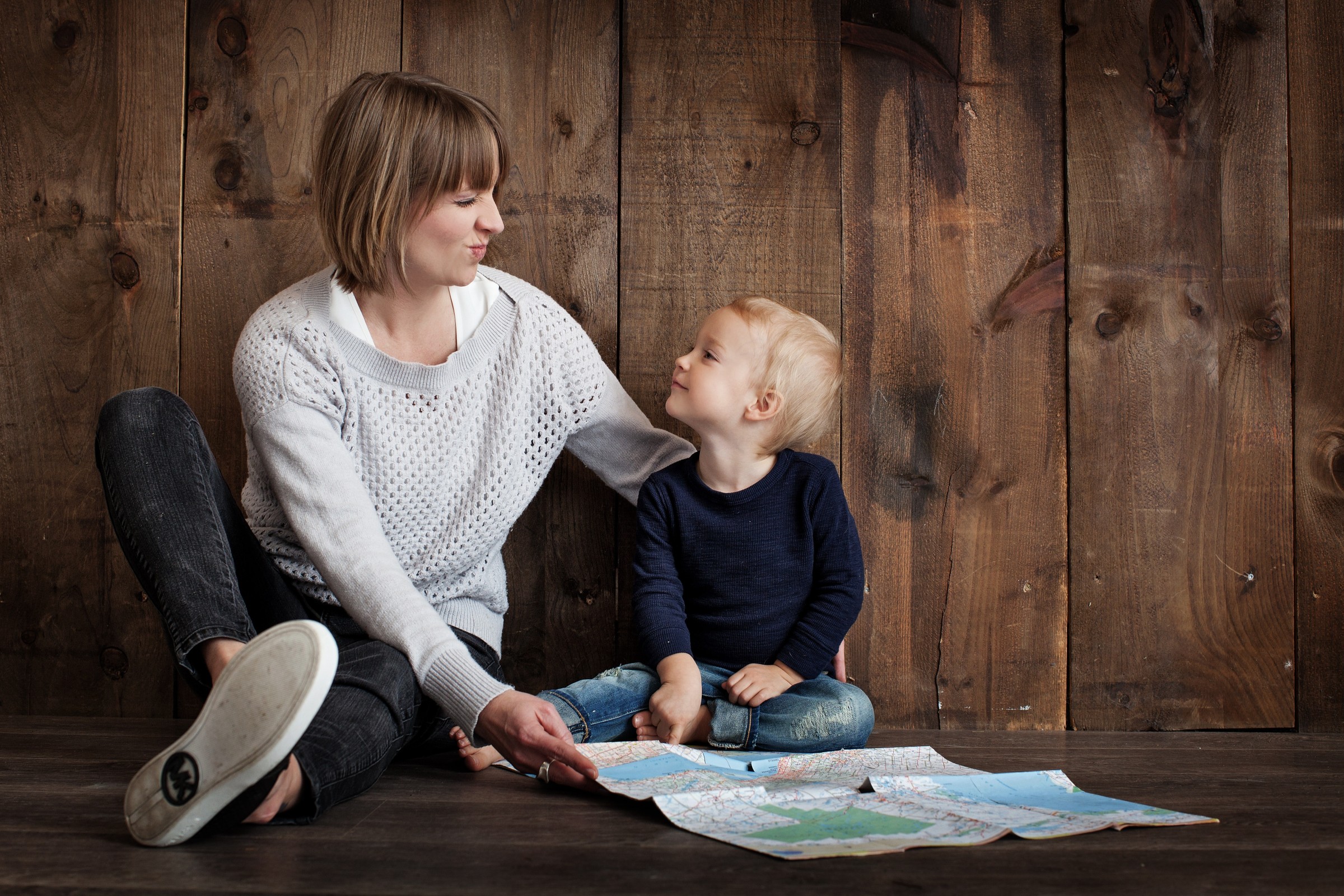 Mom and young child reading a map together.