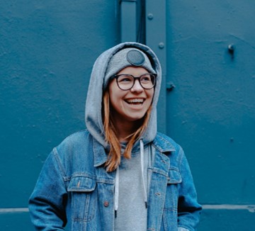 Smiling teen in front of blue walls.