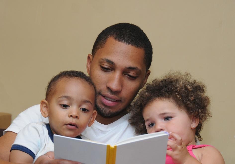 Man reads to young boy and young girl