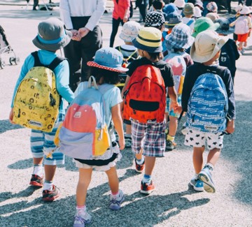 Children walking to school with backpacks on.