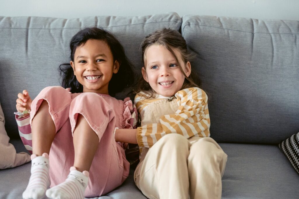 Two girls sitting on a sofa and smiling