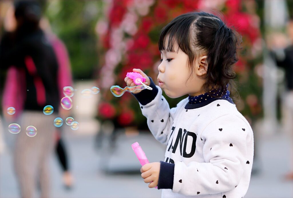 A girl blowing bubbles with a bubble wand