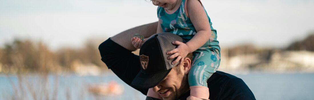 Smiling dad with daughter on his shoulders.