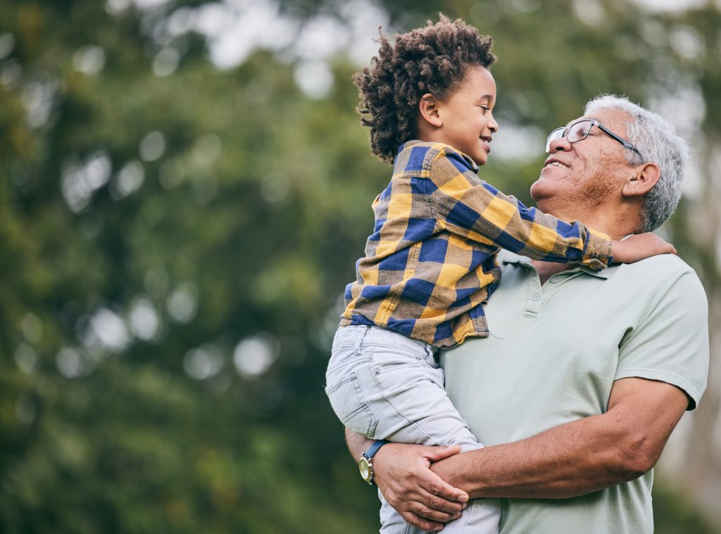 Grandfather holds smiling preschooler.
