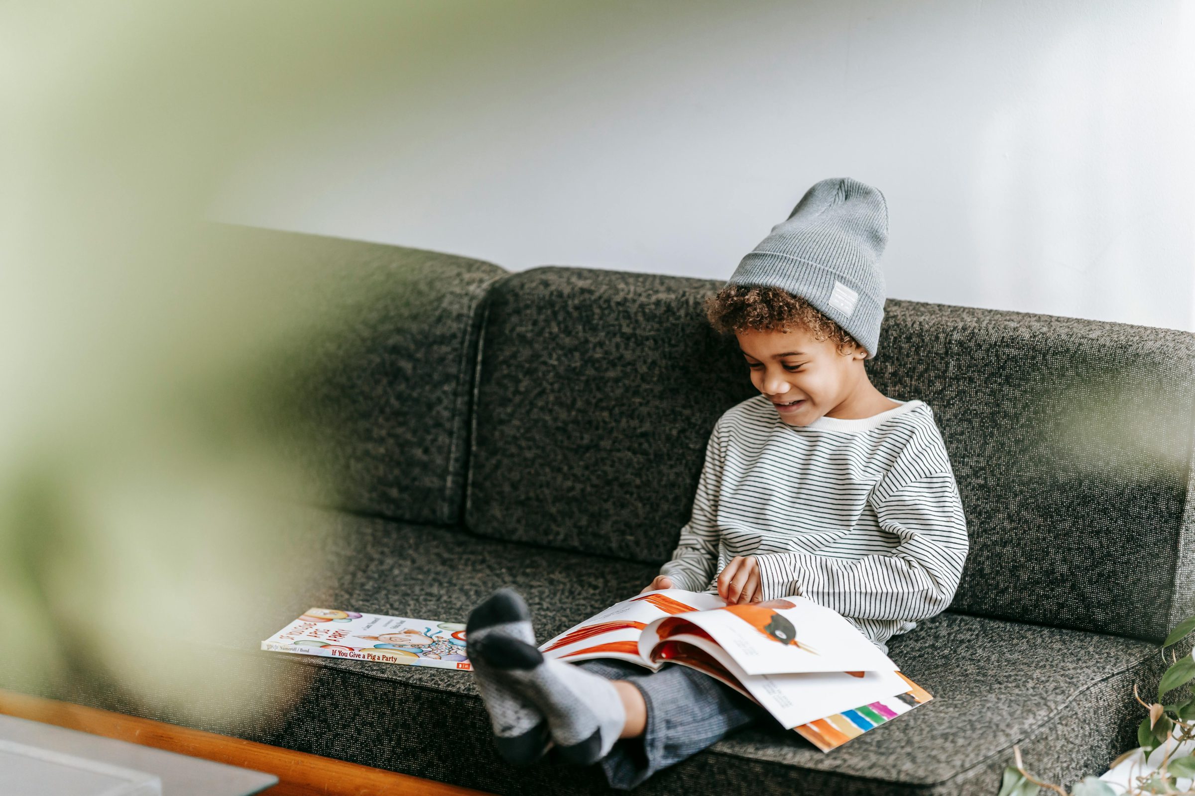 Child reading book and smiling.