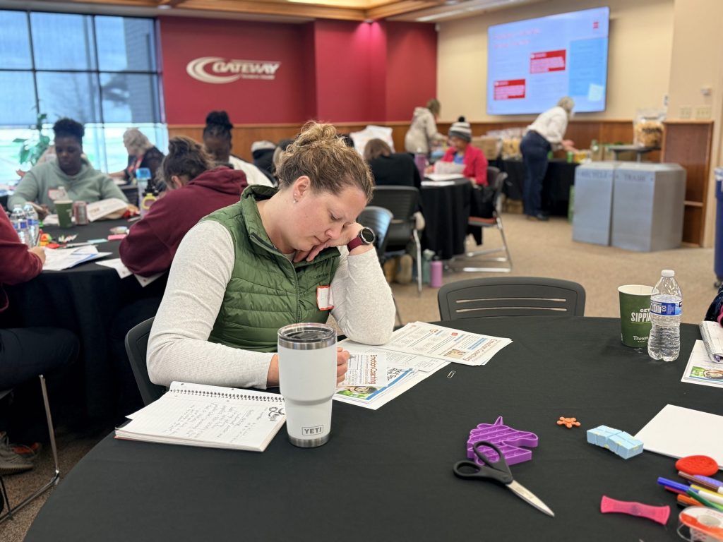 A woman fills out a workshop during an in-person emotion regulation workshop
